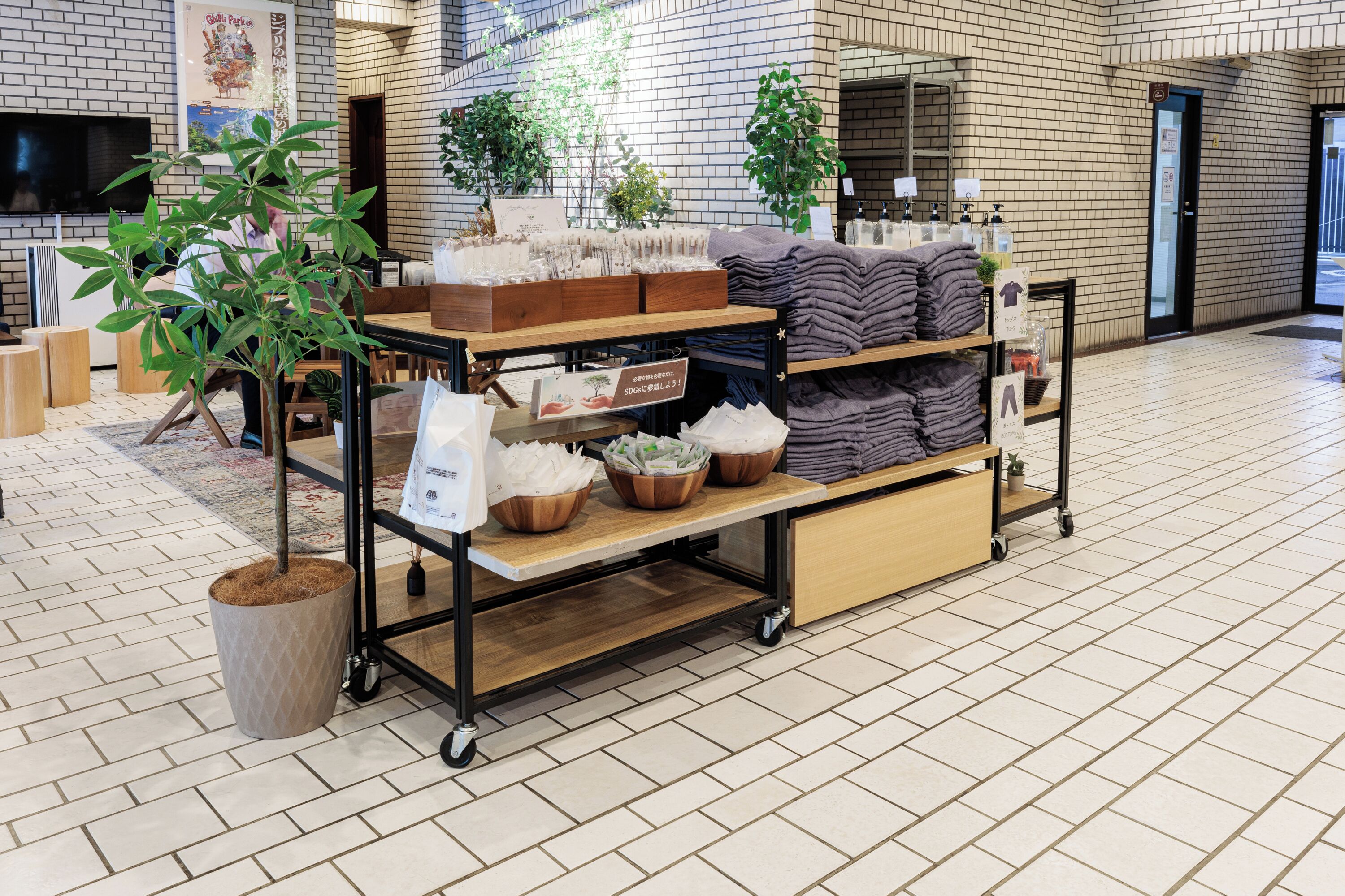A retail display with various items including towels, plants, and a sign.