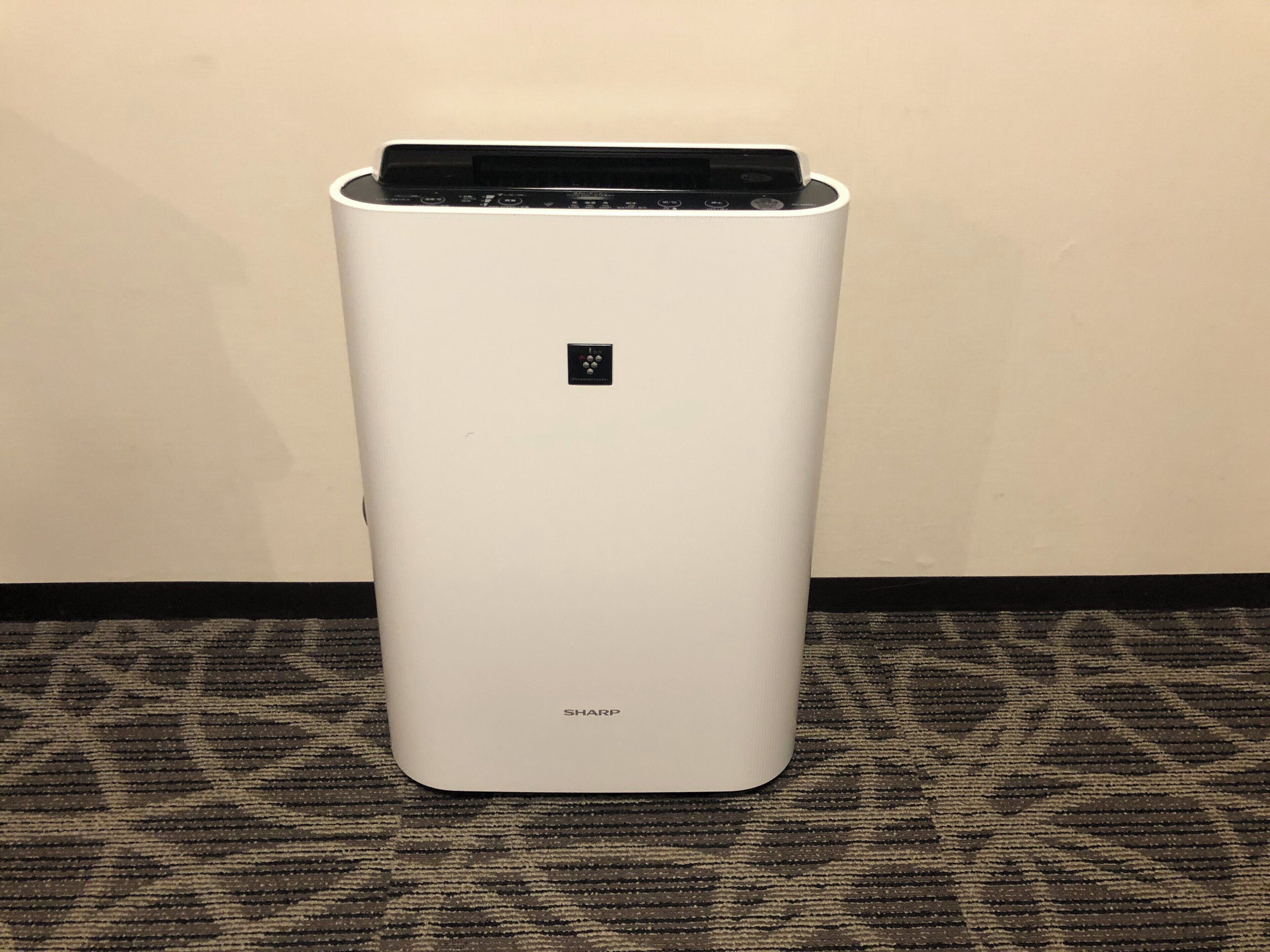 A white, modern air conditioning unit with a control panel on top and the brand name 'SHARP' at the bottom.