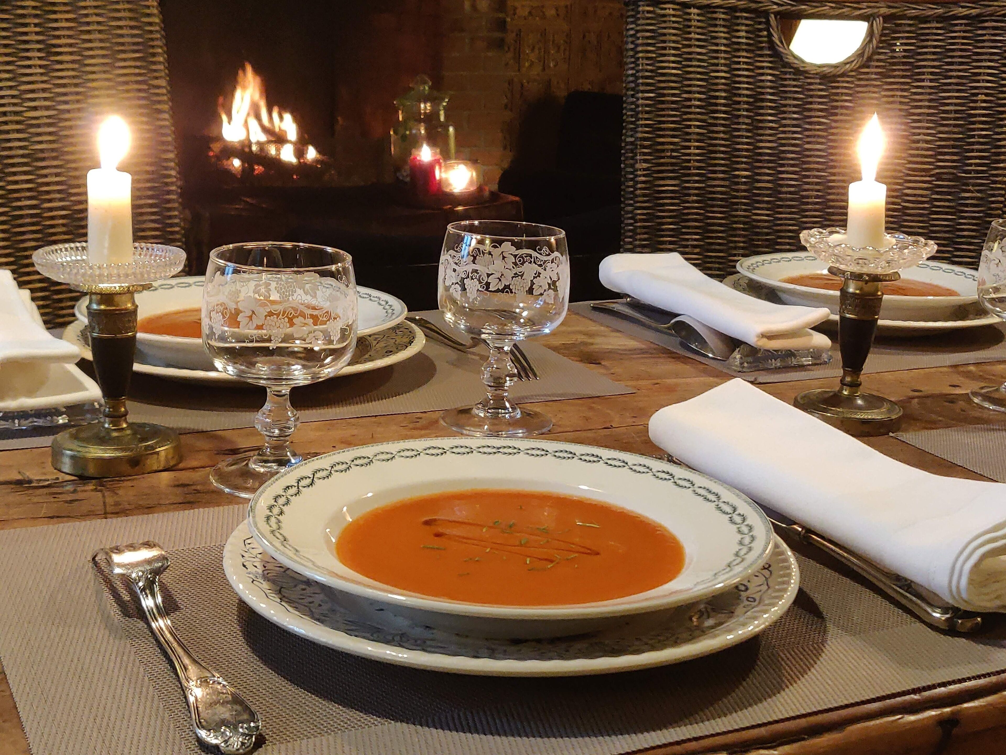 Ein gedeckter Tisch mit Feuer im Hintergrund.