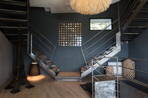A modern interior with a staircase, a decorative wall panel, and a unique lamp. - La Maison de Crillon (Crillon-le-Brave)