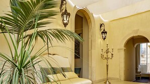Una habitación con una cama, un candelabro y una planta grande.