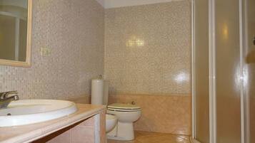 A bathroom with a sink, toilet, and shower.