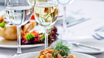 Ein Esstisch mit einer Pastasalatschale und drei Gläsern Weißwein.