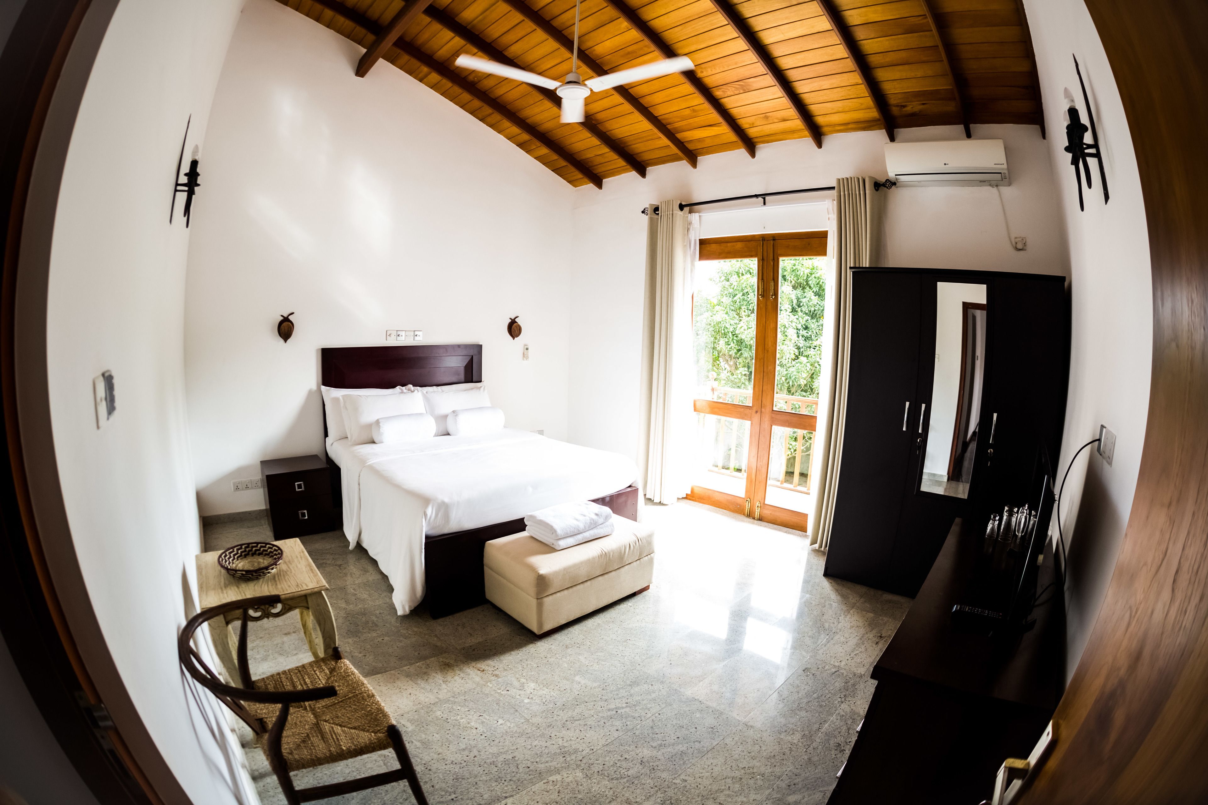 A bedroom with a bed, bedside table, chair, and a desk with a computer.