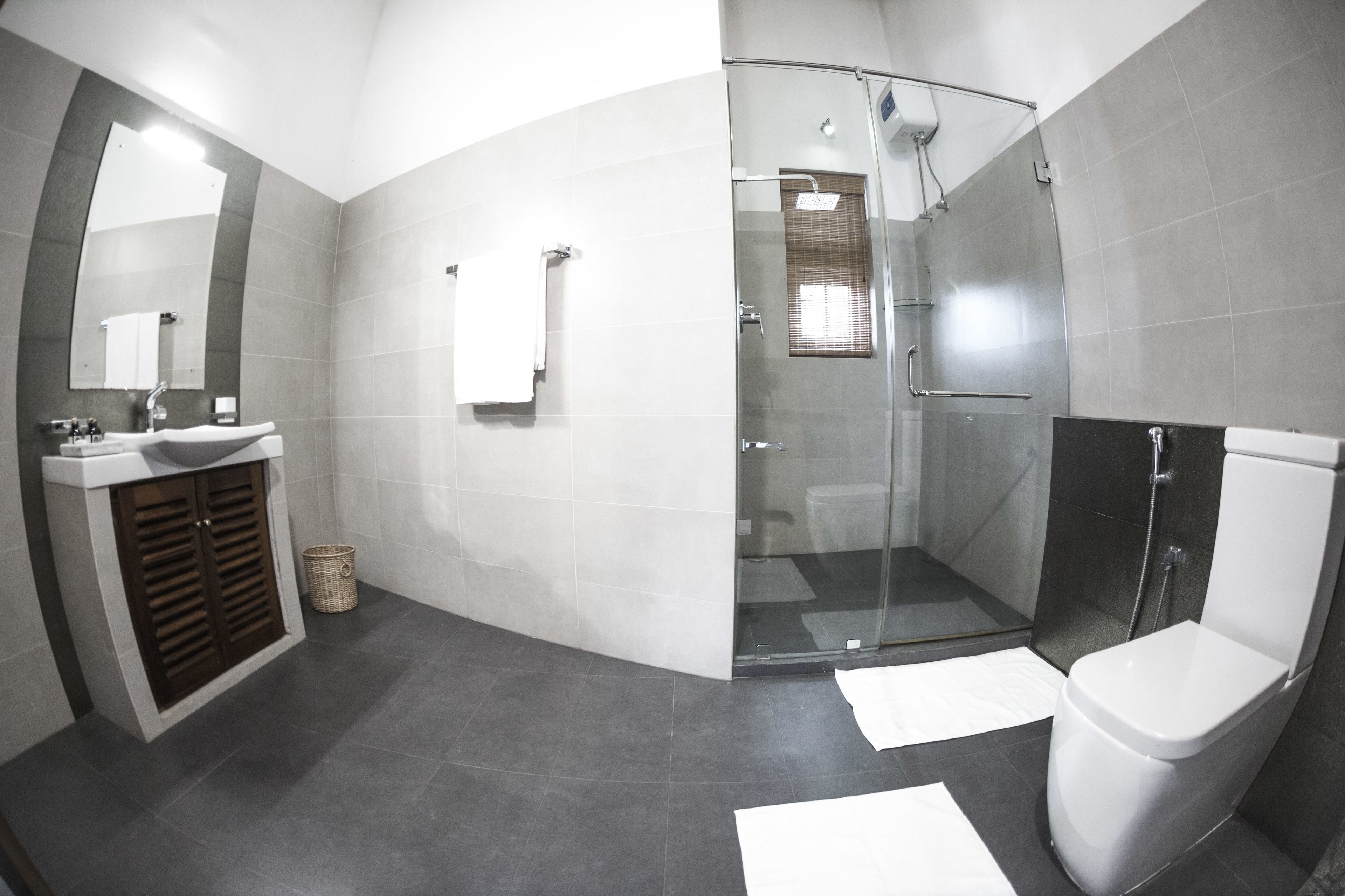 Un bagno moderno con doccia vetrata, lavandino bianco e water.