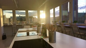 Moderni keittiö, jossa on suuri keittiösaareke, runsaasti luonnonvaloa ja näkymä kaupunkimaisemaan.
