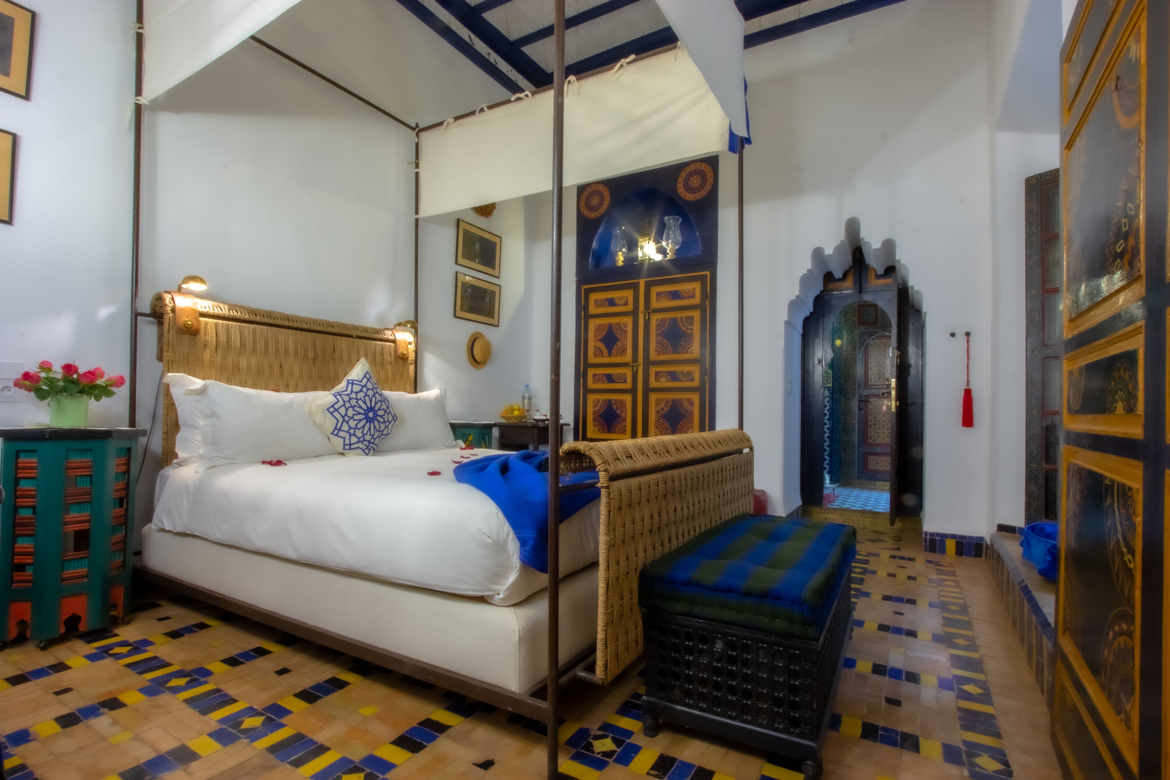 Une chambre à coucher comprenant un lit, un banc, une table de chevet et un mur orné de panneaux décoratifs.