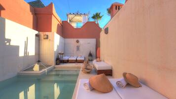 Una piscina al aire libre, tumbonas