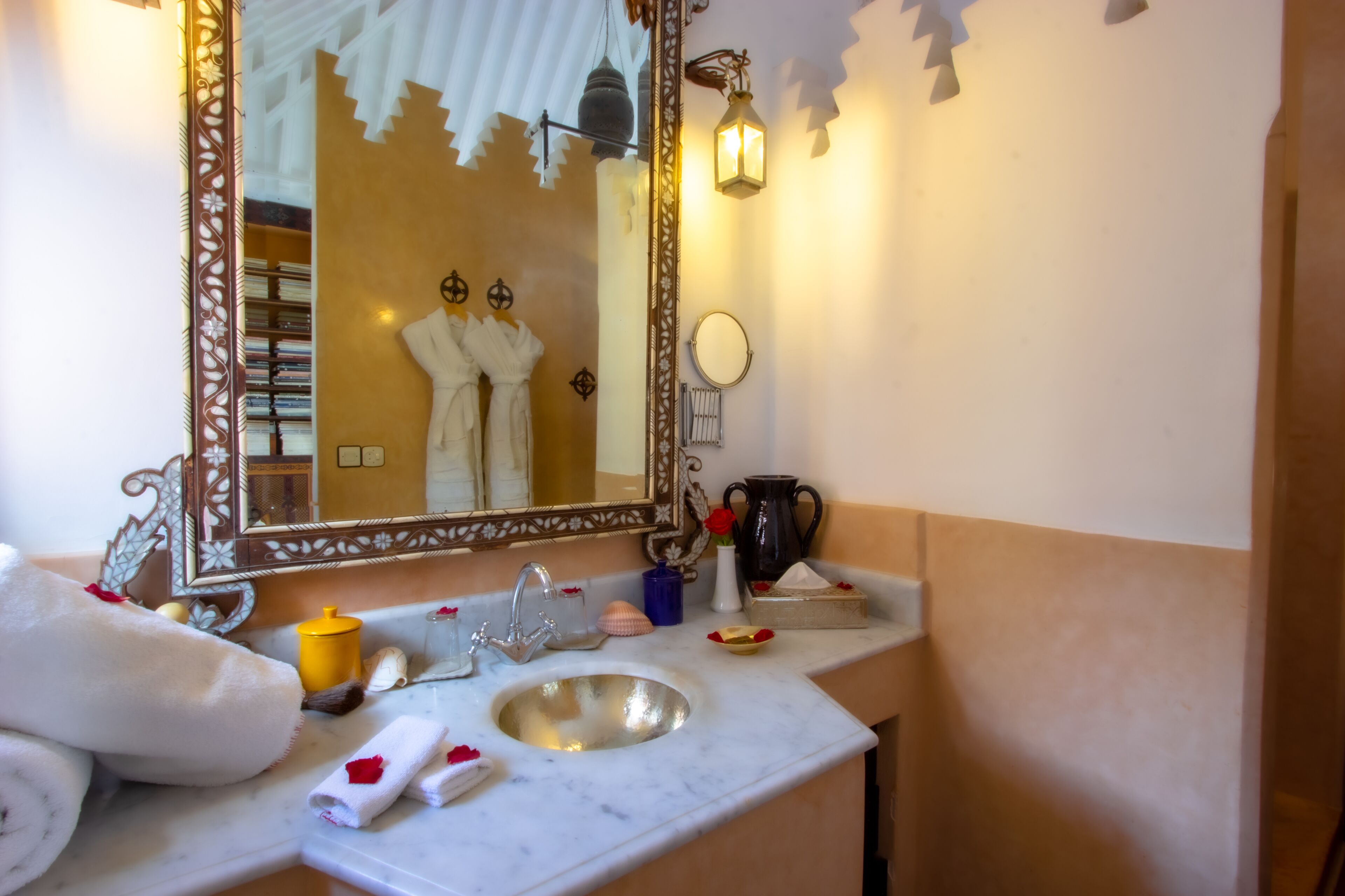 A bathroom with a marble sink, a large mirror, and a towel rack.