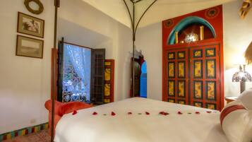 Un dormitorio con cama, armario y puerta decorada.