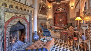 A traditional Moroccan interior with a tiled fireplace, ornate furniture, and decorative lighting. - Riad Kaiss by Anika (Marrakech)