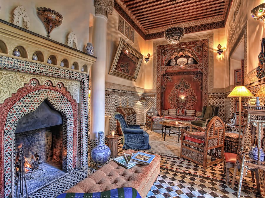 Um interior marroquino tradicional com lareira em azulejos, mobiliário ornamentado e iluminação decorativa.