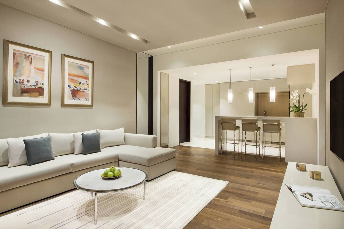 A modern living room with a sofa, coffee table, and artwork on the wall.