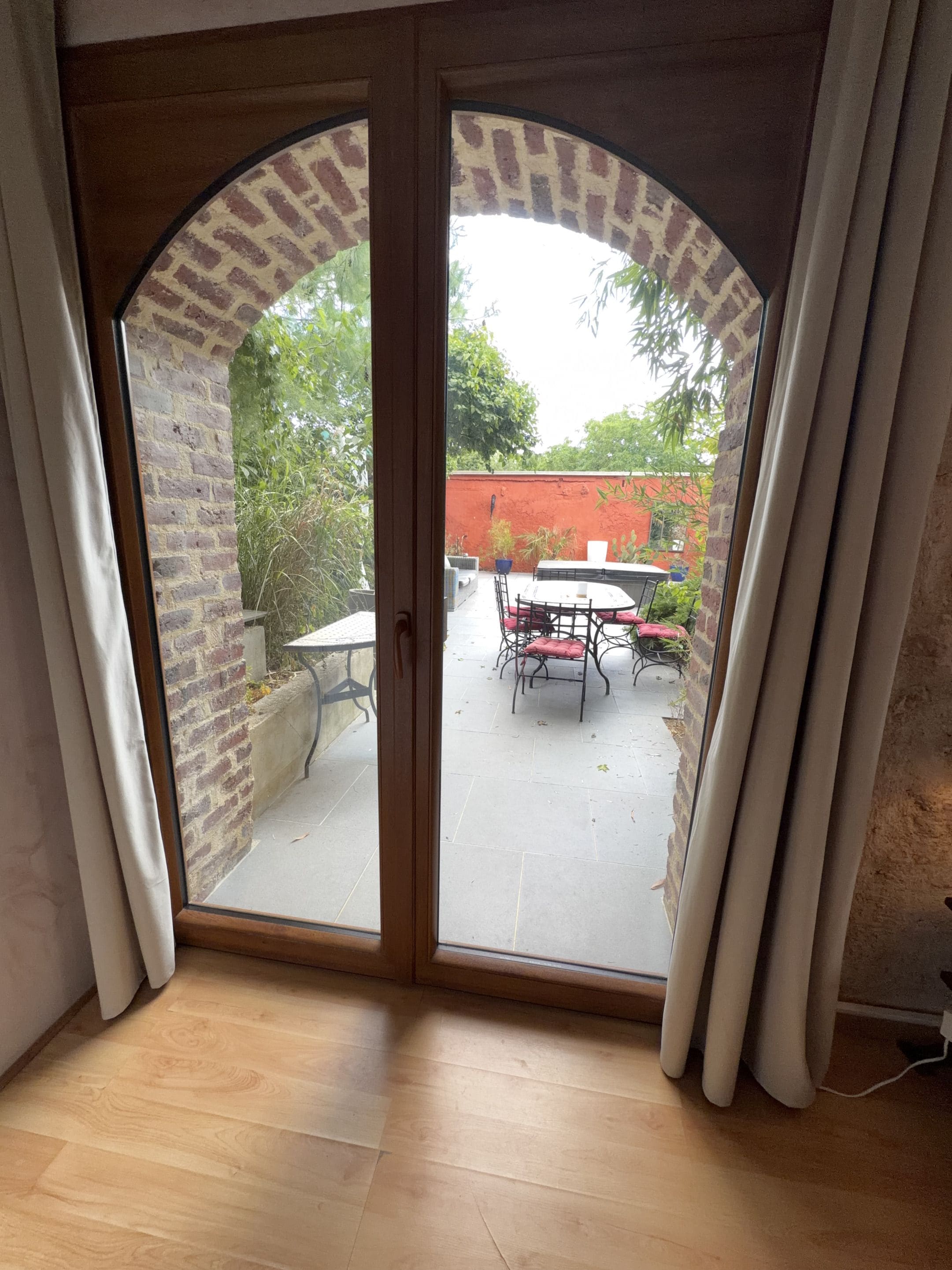 A room with a sliding glass door leading to an outdoor patio area with a table and chairs.