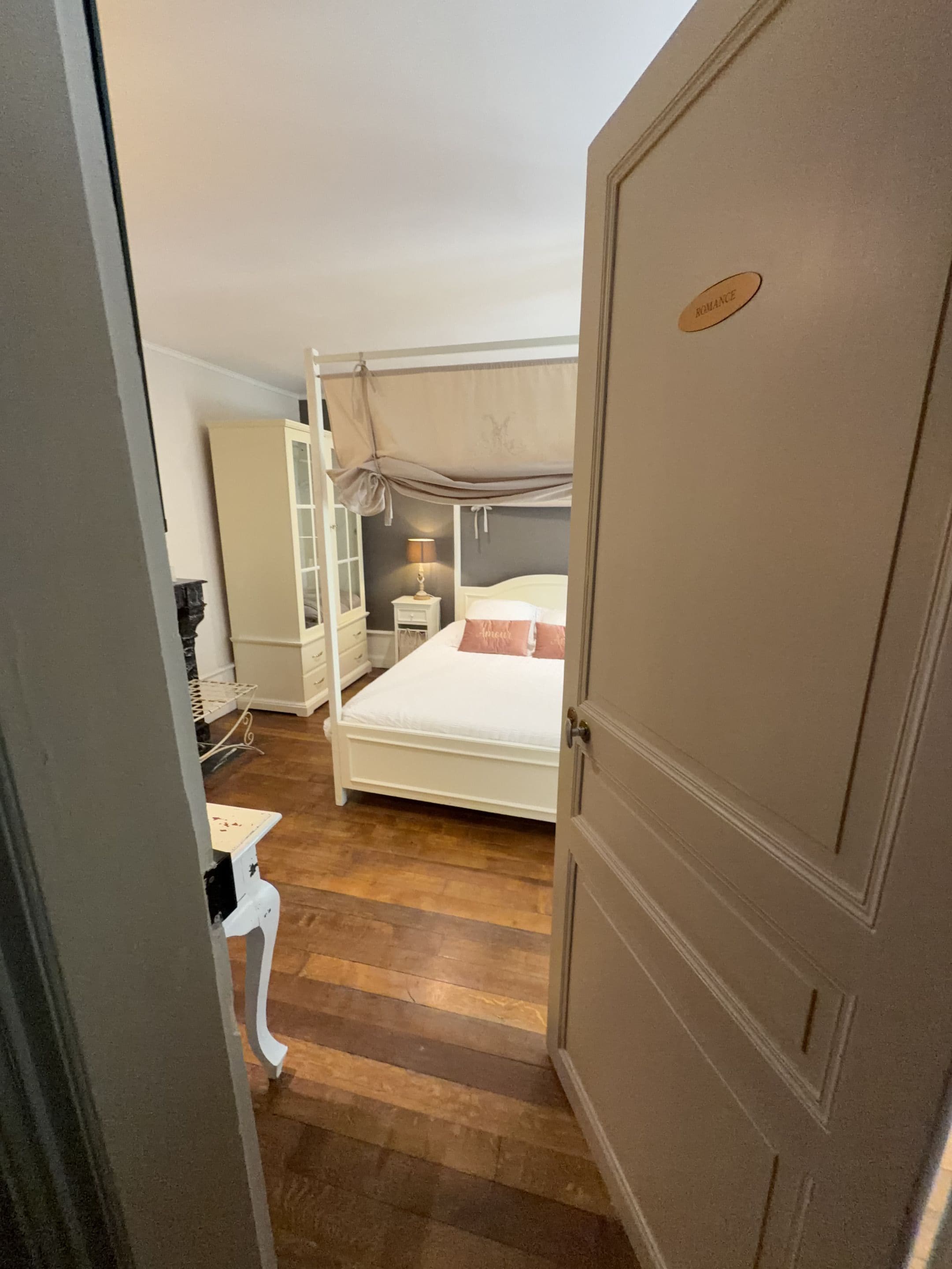 A bedroom with a bunk bed, a bedside table with a lamp, and a wardrobe.