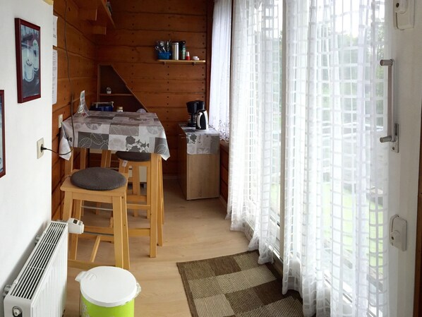 L’intérieur d’un chalet accueillant, avec un coin repas, une petite cuisine et un radiateur.