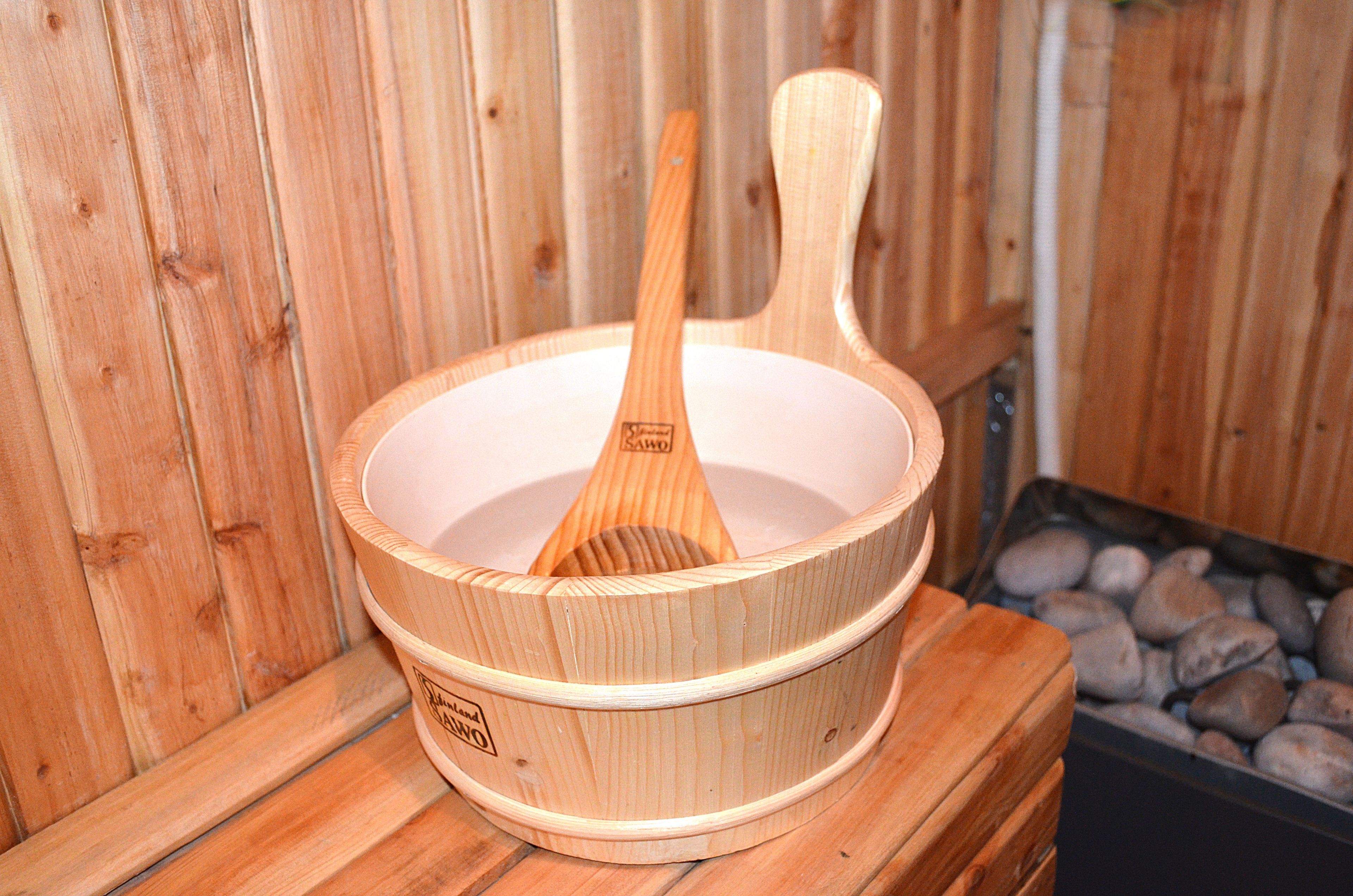 A wooden sauna with a wooden ladle inside.