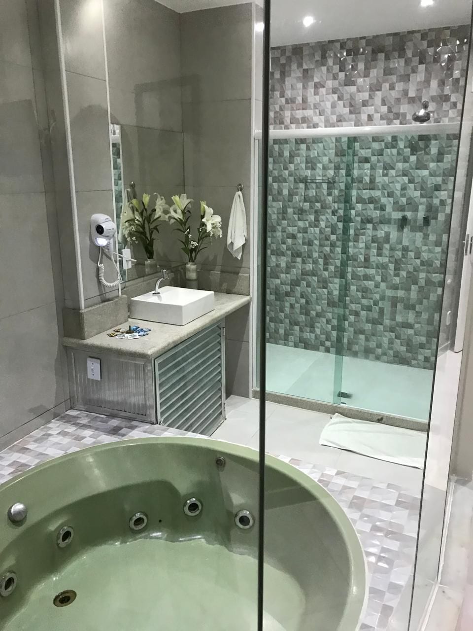 Une salle de bain moderne dotée d’une douche à parois de verre, d’une baignoire sur pieds et d’un meuble-lavabo avec un miroir.