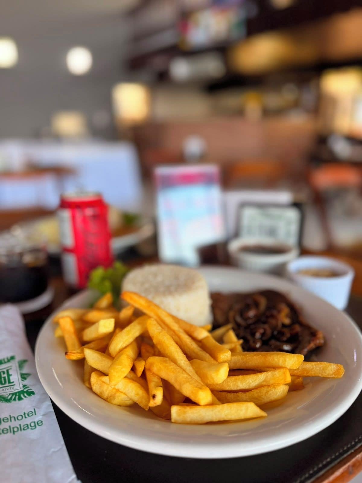 A plate of food with fries, a burger, and a side of sauce.