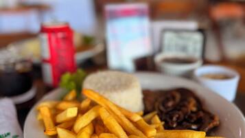 A plate of food with fries, a burger, and a side of sauce.