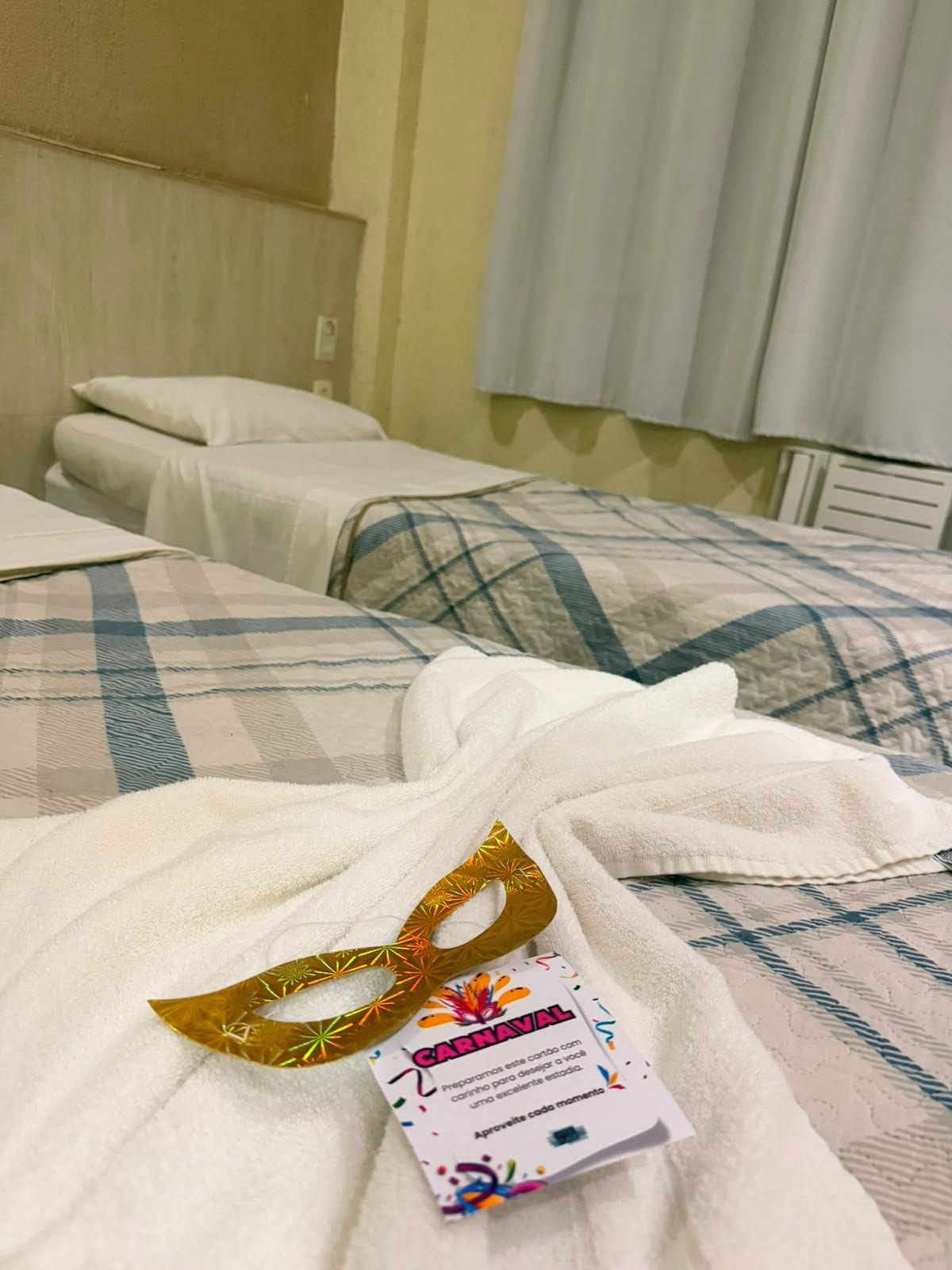 Hotellihuone, jossa on kaksi sänkyä, ja jokaisessa on eri kuvioitu vuodevaate.