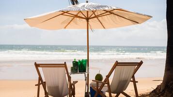 Una playa cerca, arena blanca, sillas reclinables de playa, sombrillas