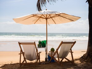 In Strandnähe, weißer Sandstrand, Liegestühle, Sonnenschirme