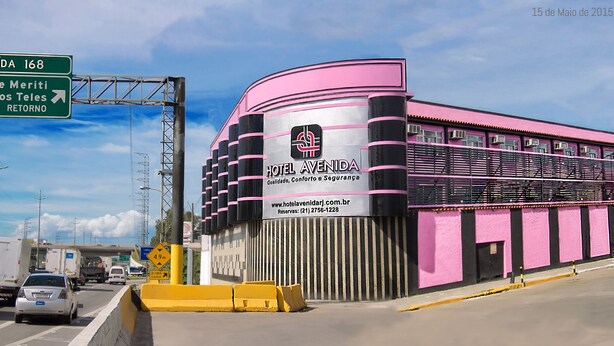 A pink and black building with a sign for Hotel Avenida, indicating a location near S. J. de Meriti and Vilar dos Teles. - Hotel Avenida (São João de Meriti)