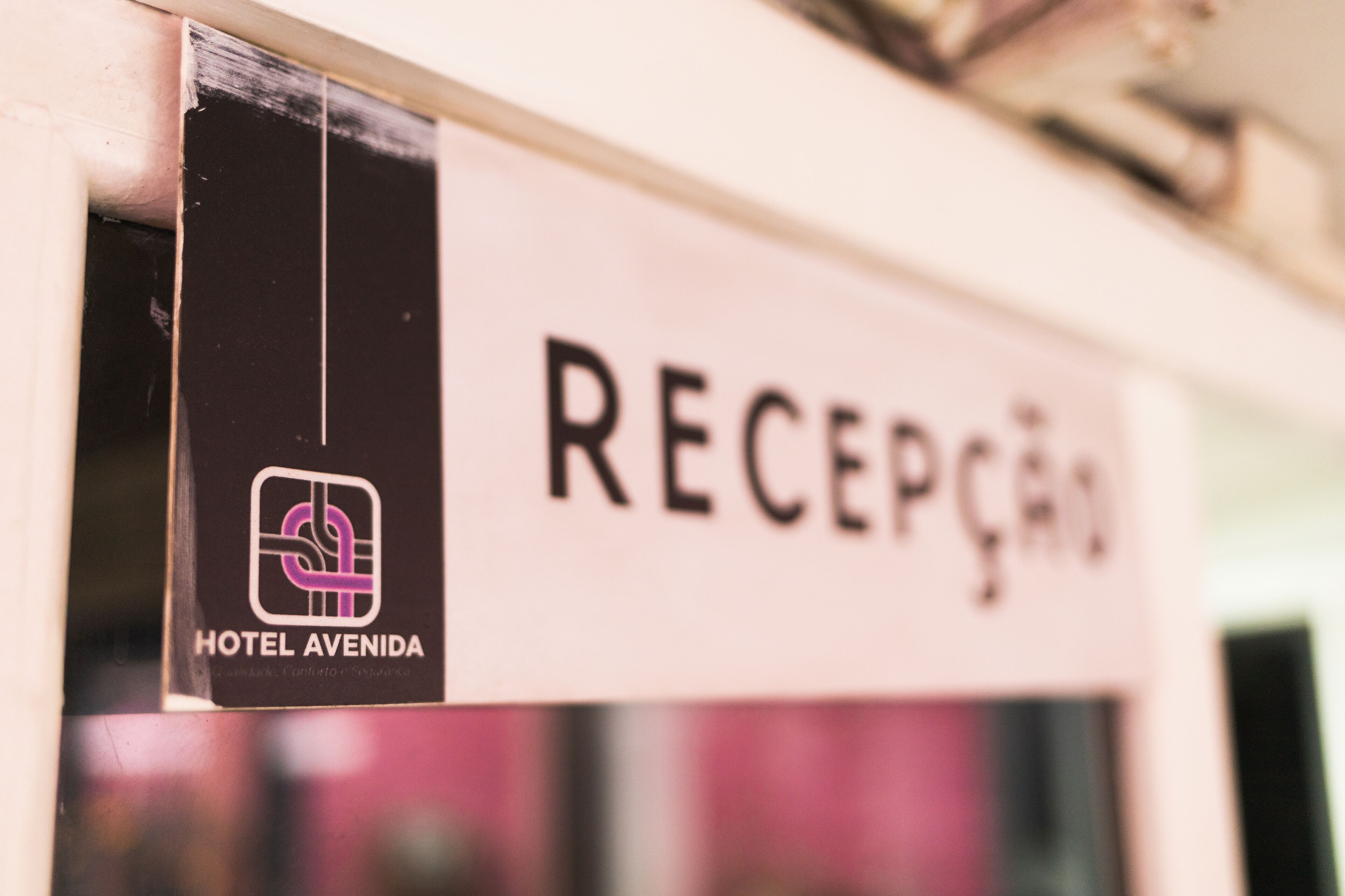 Un'area reception di un hotel con un cartello che riporta la scritta "RECEPTION" e il logo "HOTEL AVENIDA".