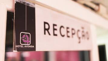 Zona de recepción de un hotel, con un letrero que dice "RECEPTION" y el logotipo de "HOTEL AVENIDA".