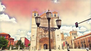 Una catedral histórica con arquitectura detallada, un farol y un semáforo al frente.