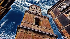 A tall, historic tower with a clock, surrounded by other buildings. - Hostal Ramón y Cajal (Valladolid)