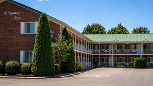 A two-story building with a brick facade and a green roof, labeled 'Alleghany Inn.'