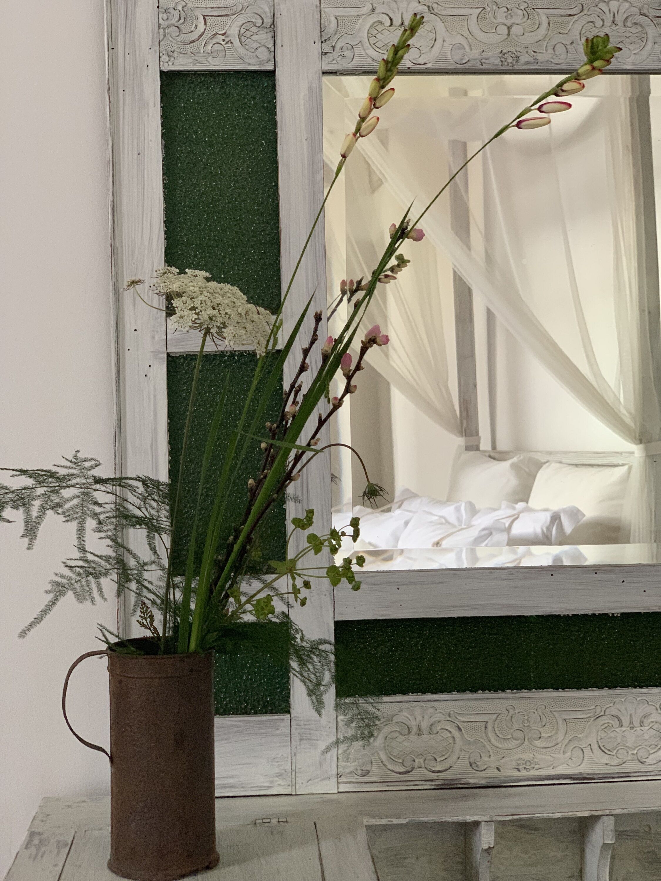 A rustic vase with a plant on a wooden surface.