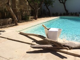 Una piscina al aire libre, sillones reclinables de piscina