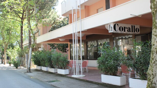 A hotel named 'hCorallo' with outdoor seating and potted plants. - Hotel Corallo (San Mauro Pascoli)