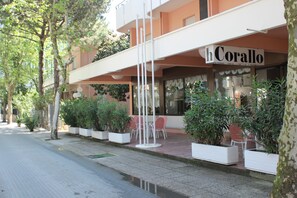 Ein Hotel namens 'hCorallo' mit Außenbereich und Pflanzen in Töpfen.