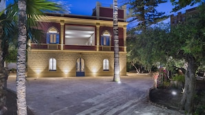 A building with a symmetrical facade, arched windows, and a central entrance. - Giardini Mon Plaisir (Trapani)