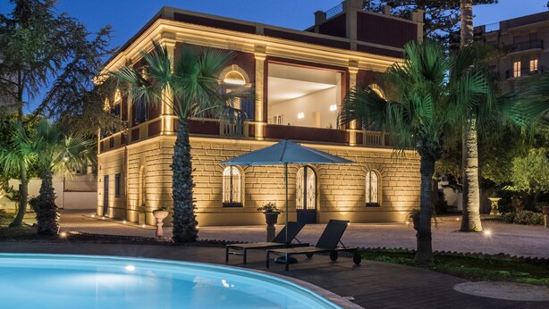 A luxurious house with a swimming pool, a covered patio, and a well-lit exterior. - Giardini Mon Plaisir (Trapani)