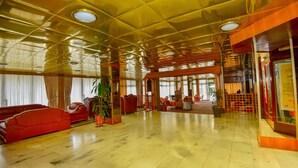 A spacious lobby with a high ceiling, polished marble floors, and red seating. - Ghion Hotel (Addis Ababa)