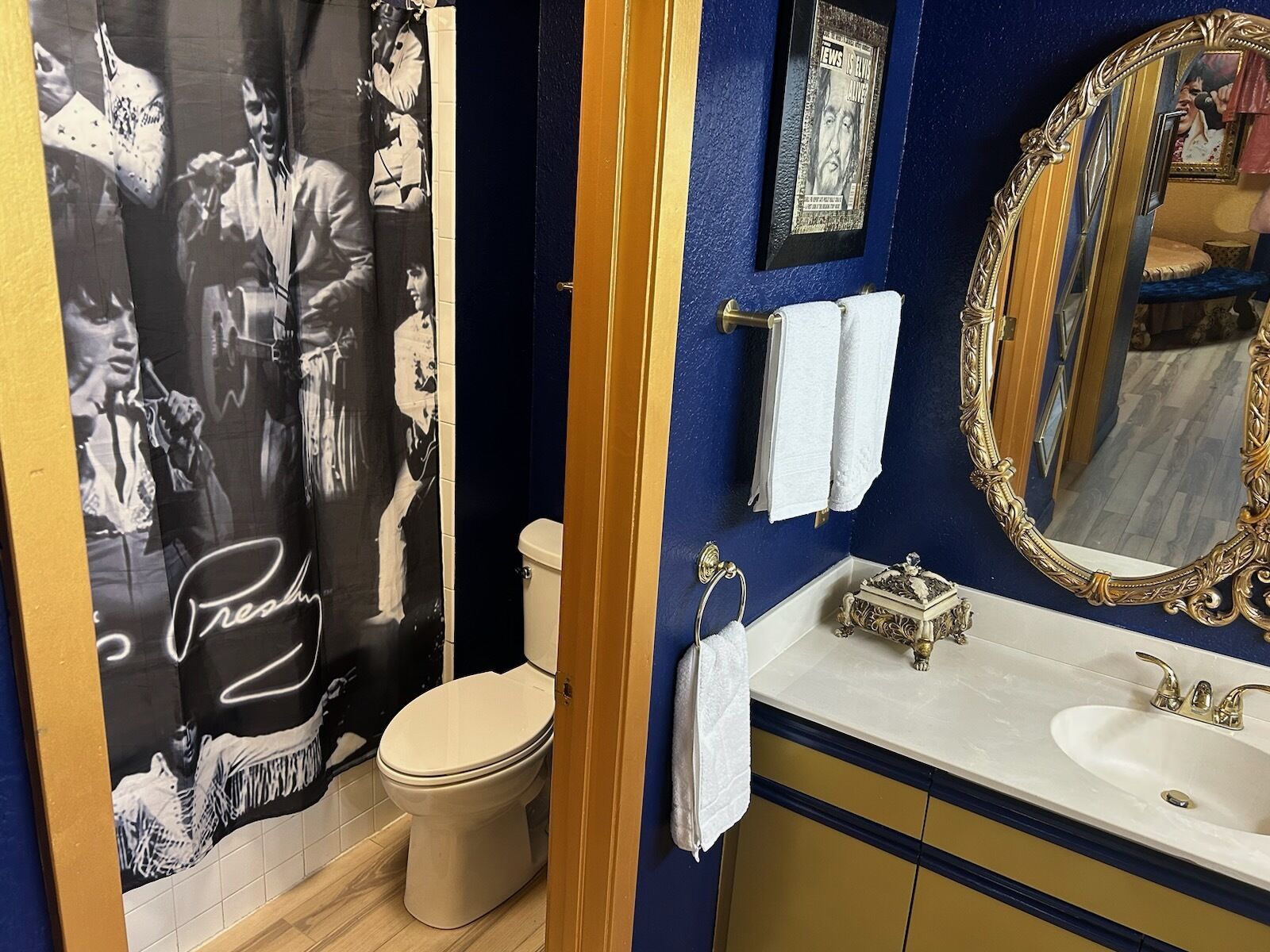 A bathroom with a toilet, sink, and mirror.