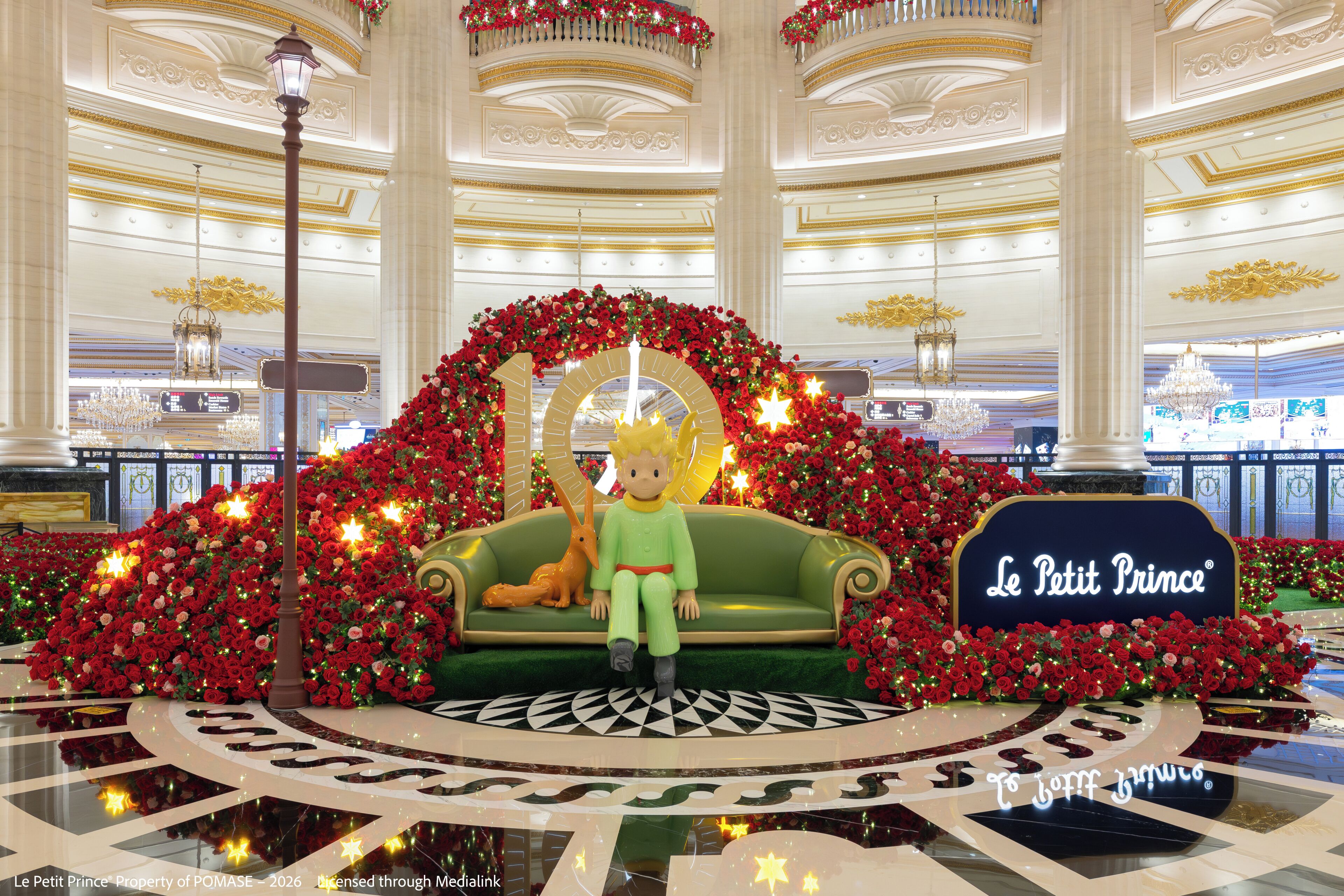 A grand lobby with a central seating area, a chandelier, and a sign reading 'Le Petit Prince'.