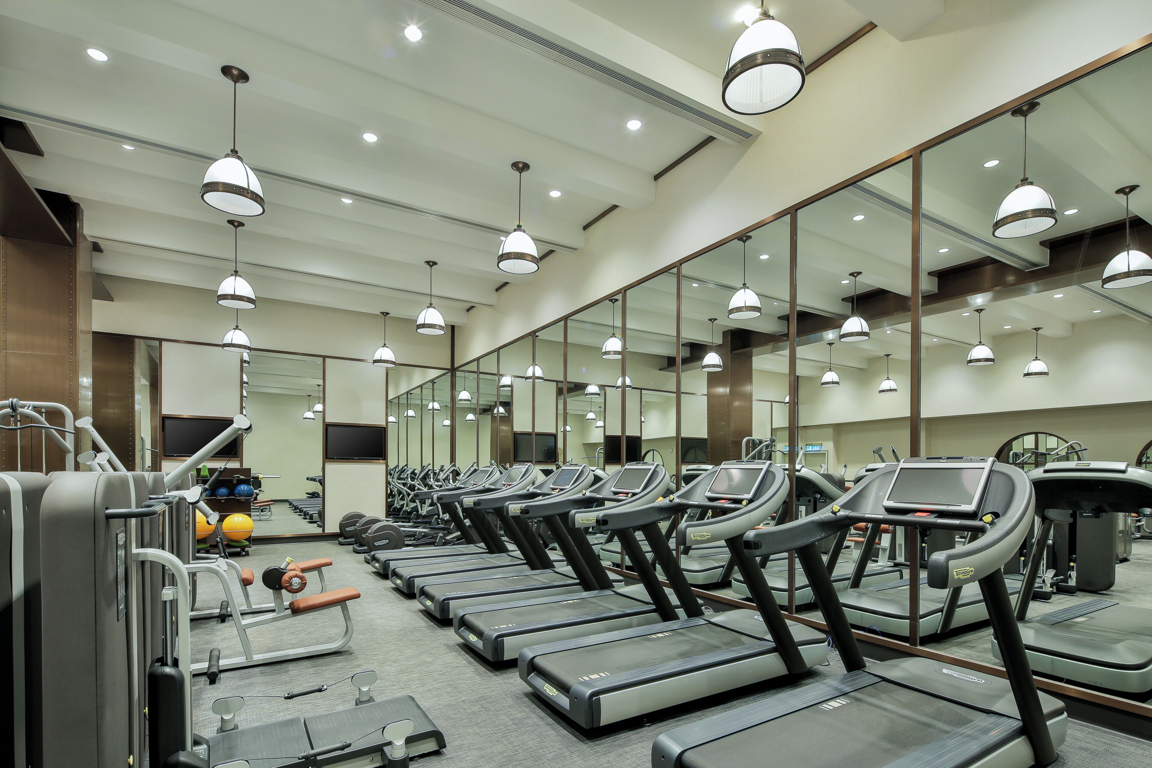 A gym with treadmills, weight machines, and exercise balls.