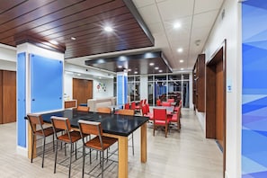 A modern meeting room with a large table and chairs, wooden accents, and glass partitions.