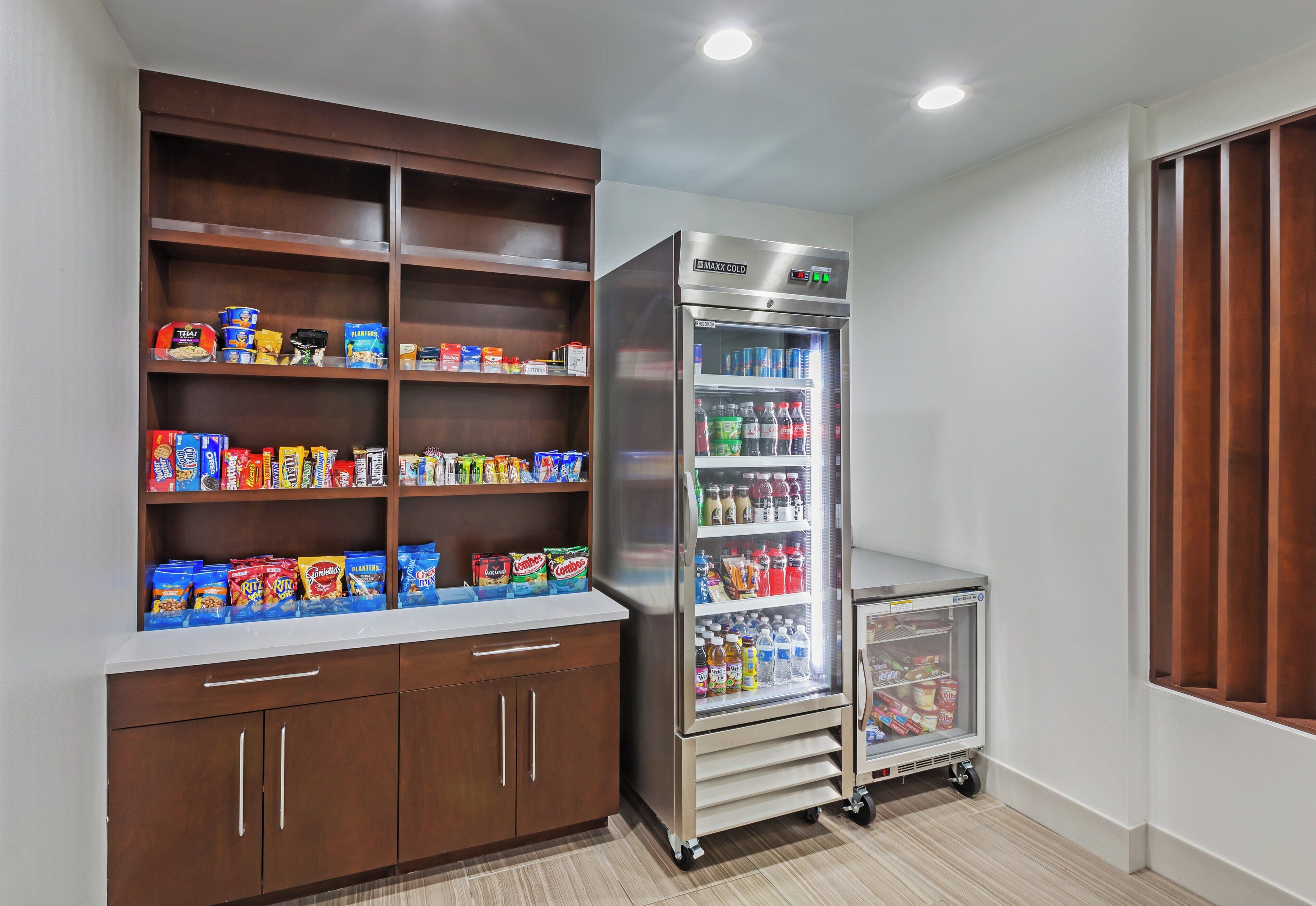 A kitchenette with a refrigerator, pantry, and a small cart.