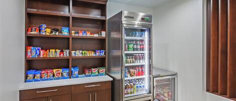 A kitchenette with a refrigerator, pantry, and a small cart.