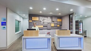 Un comptoir d’accueil au design moderne, doté d’un écran numérique et d’un panneau indiquant les heures d’enregistrement.