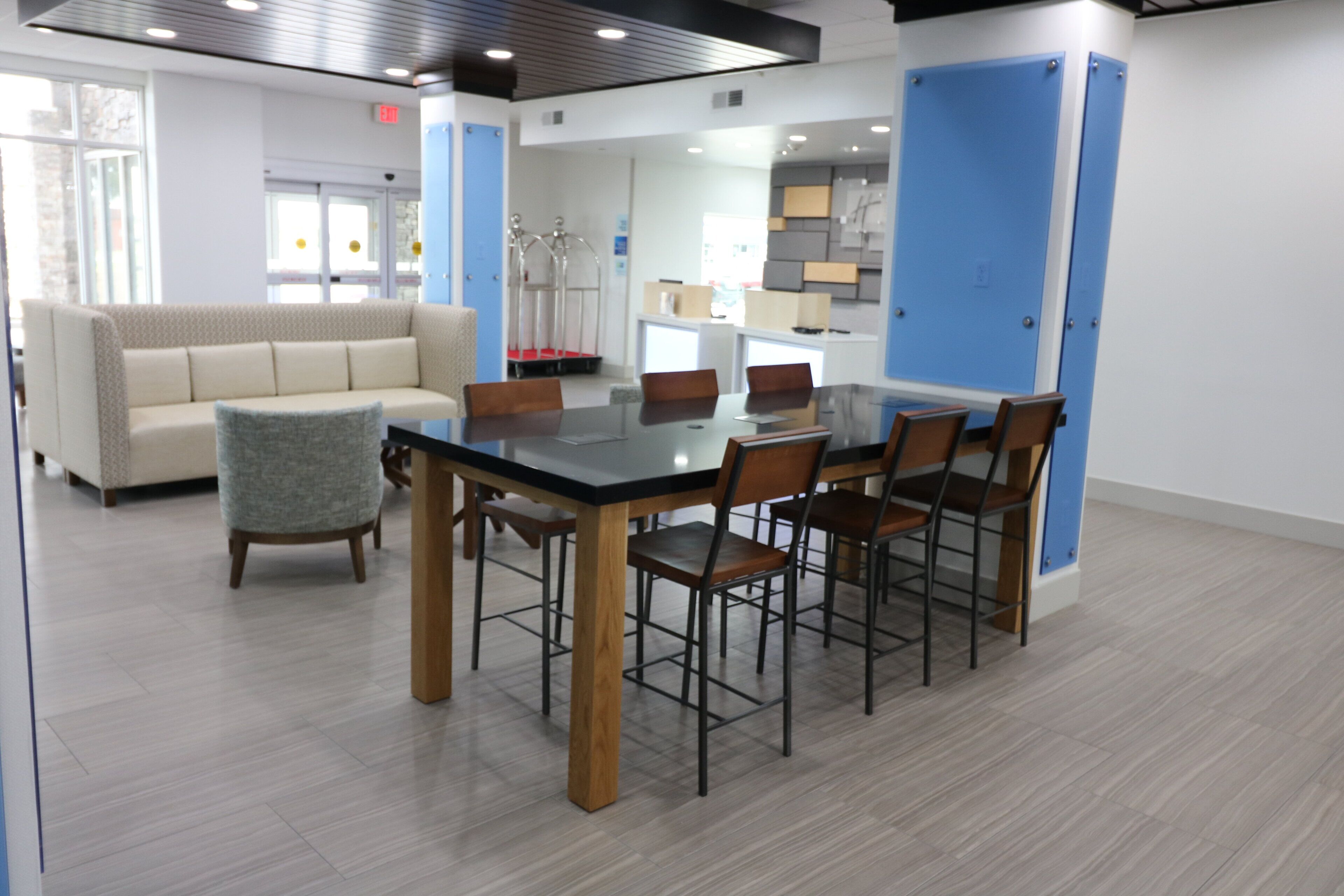 A modern interior with a dining area, a sofa, and a kitchenette.