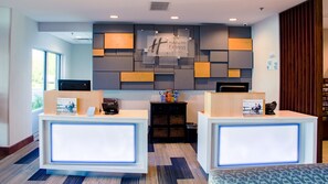 A reception area with two reception desks, a wall-mounted sign, and a bulletin board. - Holiday Inn Express & Suites Danville by IHG (Danville)
