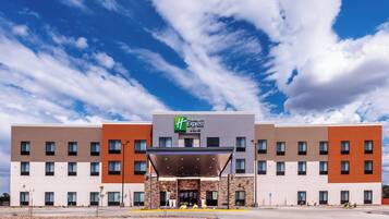 A Holiday Inn Express hotel with a modern facade, multiple floors, and a clear sky.